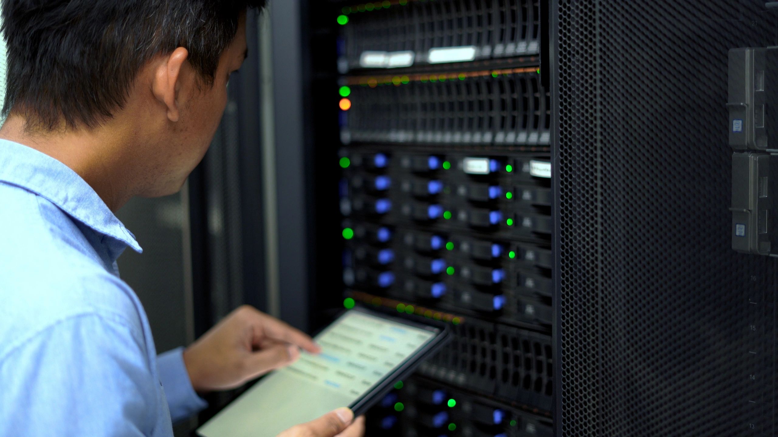 An IT technician inspects and manages a server.
